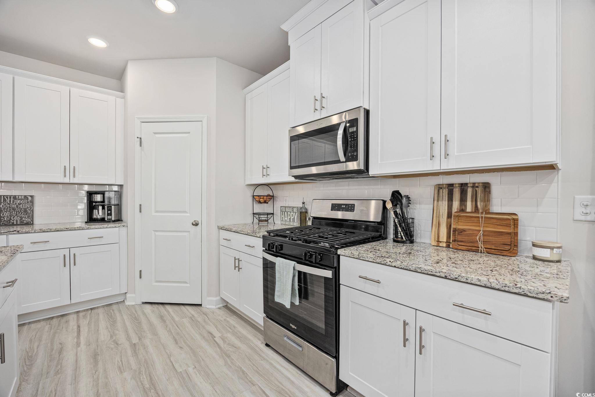 2412 Copper Mdw Loop Longs, SC 29568 - Photo 9 of 40 Kitchen with appliances with stainless steel finishes, tasteful backsplash, white cabinetry, and recessed lighting