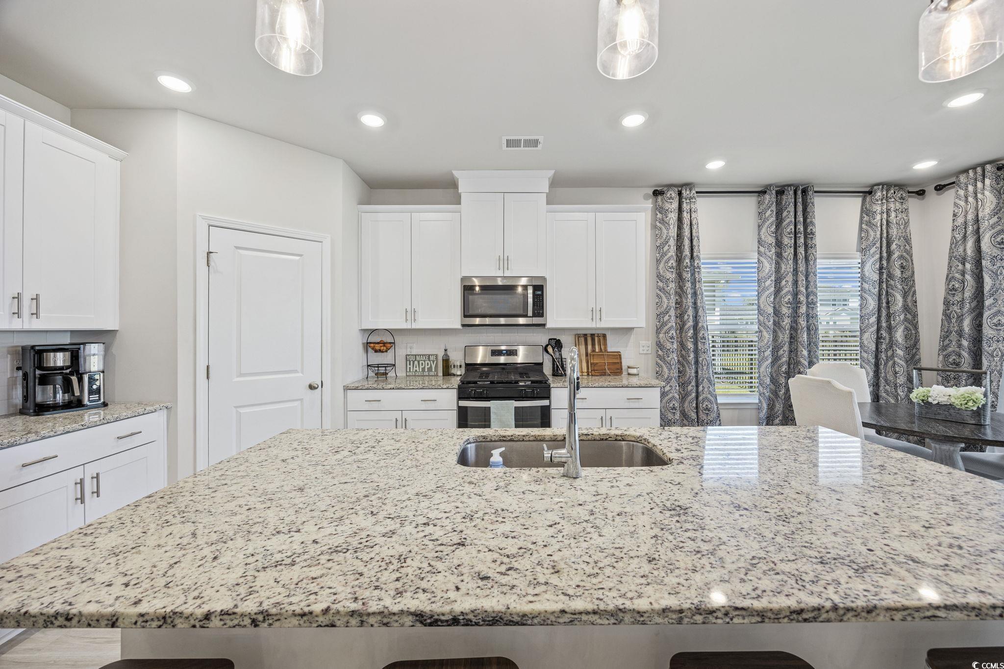 2412 Copper Mdw Loop Longs, SC 29568 - Photo 10 of 40 Kitchen featuring a kitchen breakfast bar, white cabinets, appliances with stainless steel finishes, light stone counters, and recessed lighting