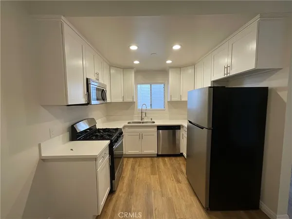 a kitchen with a refrigerator a stove top oven and a sink