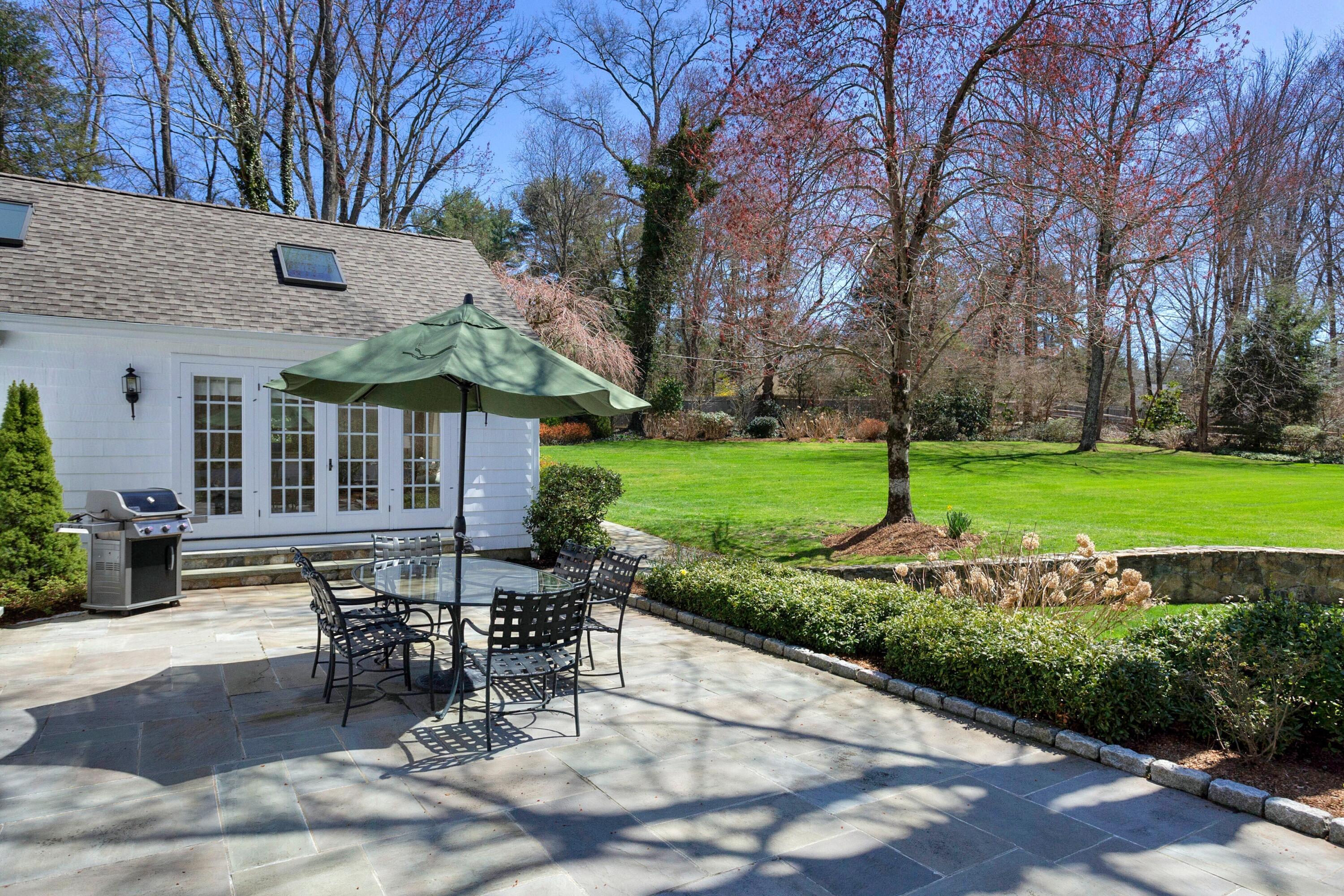 16 Half Mile Road Darien, CT 06820 - Photo 50 of 59 a view of a patio with table and chairs with wooden fence and plants