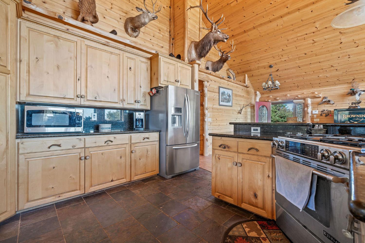 6800 West Murray Creek Road San Andreas, CA 95249 - Photo 11 of 47 a kitchen with stainless steel appliances granite countertop a refrigerator a stove and white cabinets