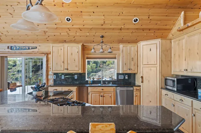a kitchen with stainless steel appliances kitchen island granite countertop a stove and a refrigerator