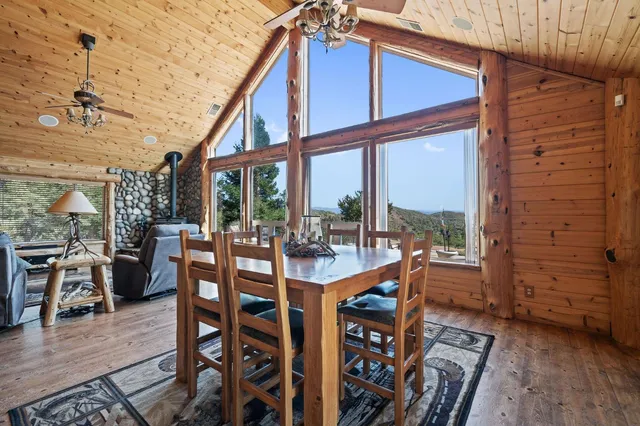 a dining room with furniture large windows and wooden floor