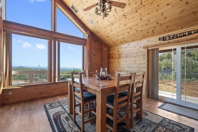 a view of a dining room with furniture large windows and wooden floor