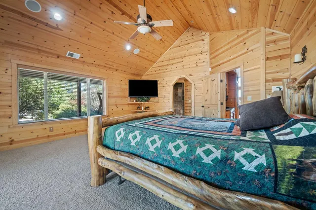 a bedroom with a bed window and flat screen tv