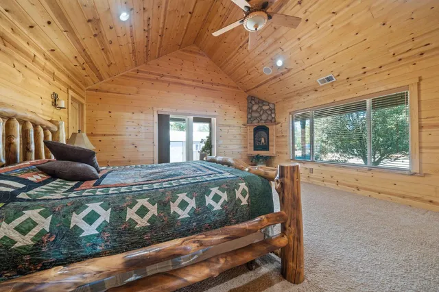 a bed sitting in a spacious bedroom next to a window