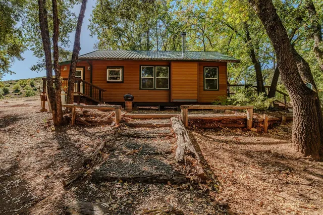 a backyard of a house with barbeque oven table and chairs