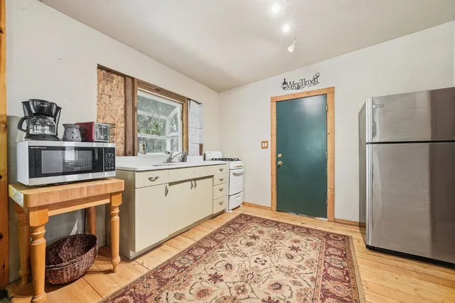 a kitchen with a refrigerator sink and cabinets