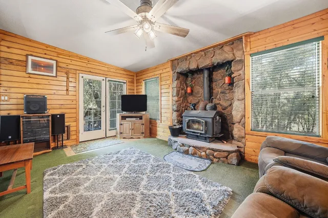 a living room with furniture a flat screen tv and a large window