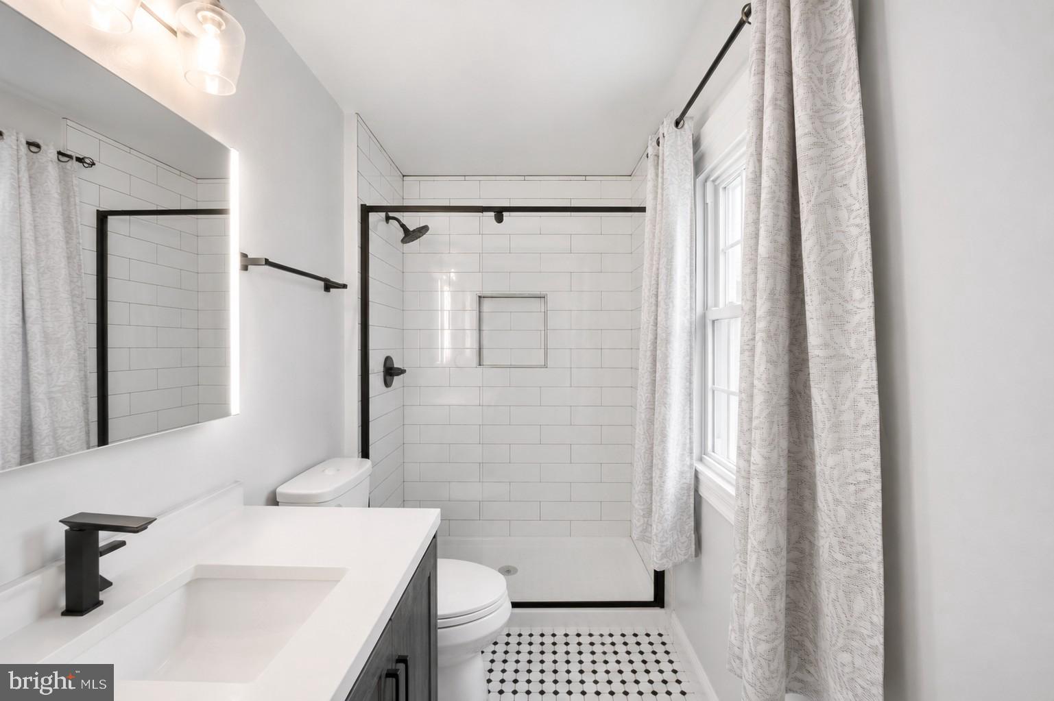 8812 Churchfield Lane Laurel, MD 20708 - Photo 22 of 31 a bathroom with a sink a toilet a shower and a window