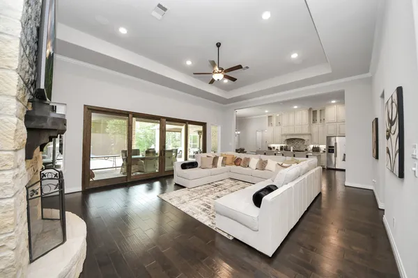 a living room with furniture large window and wooden floor