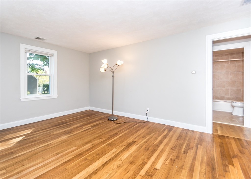 1166 Trapelo Road Waltham, MA 02451 - Photo 16 of 30 a view of an empty room with wooden floor and a window