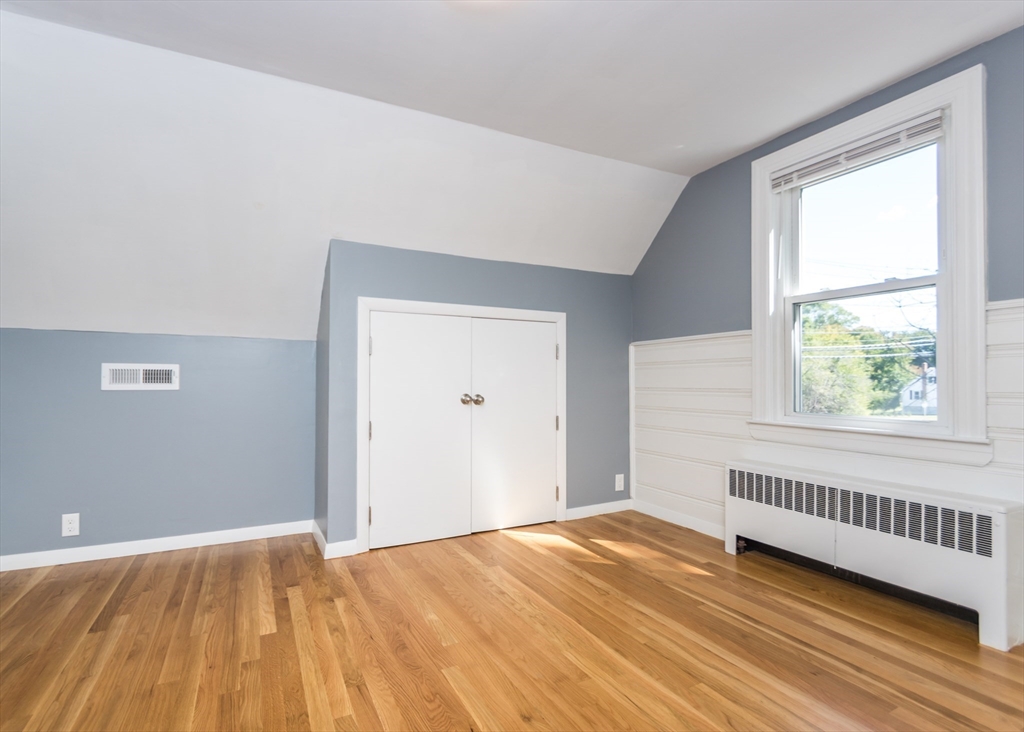 1166 Trapelo Road Waltham, MA 02451 - Photo 24 of 30 a view of an empty room with wooden floor and a window