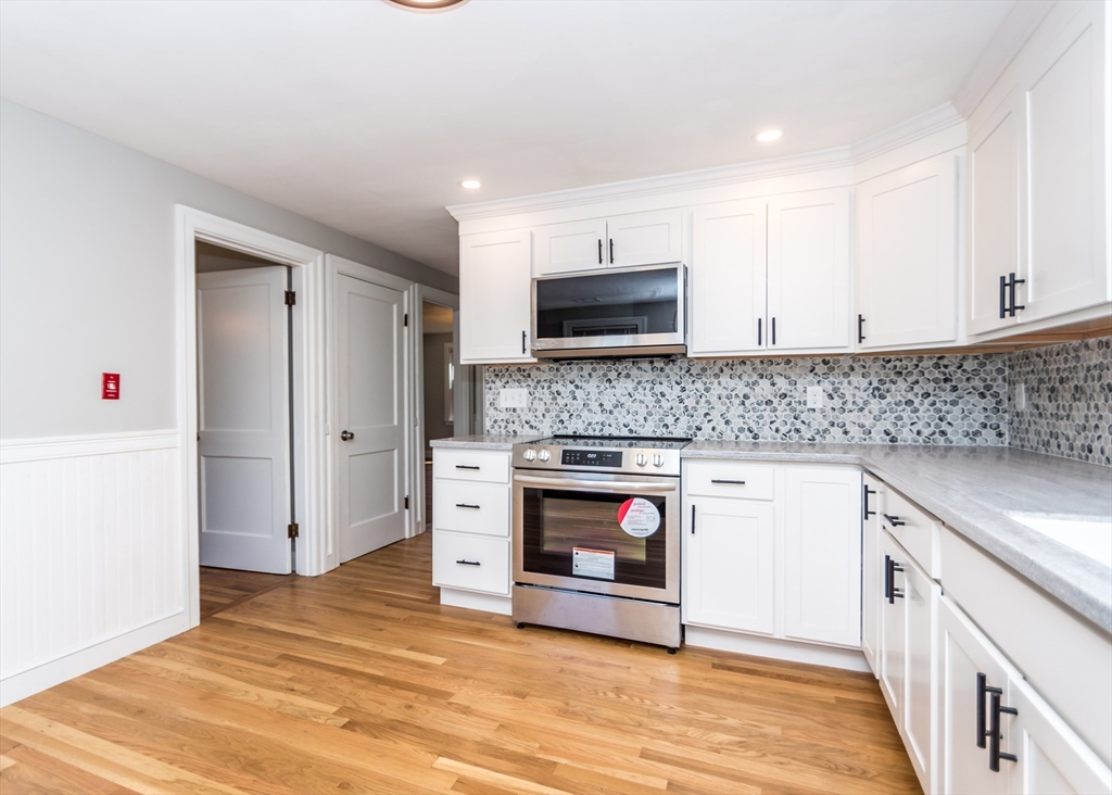 1166 Trapelo Road Waltham, MA 02451 - Photo 8 of 30 a kitchen with stainless steel appliances granite countertop a stove a sink and a microwave
