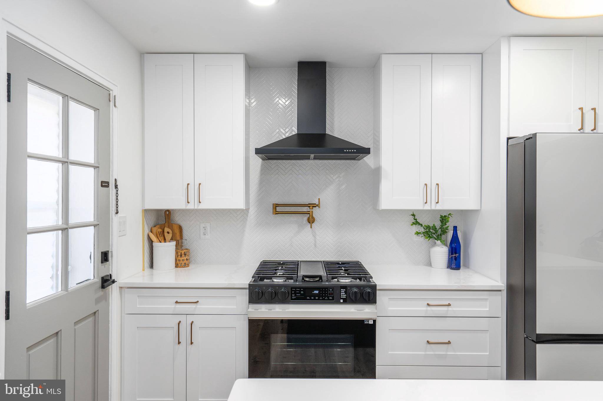 1808 Winford Road Baltimore, MD 21239 - Photo 18 of 39 a kitchen with stainless steel appliances granite countertop a stove a refrigerator and a white cabinets