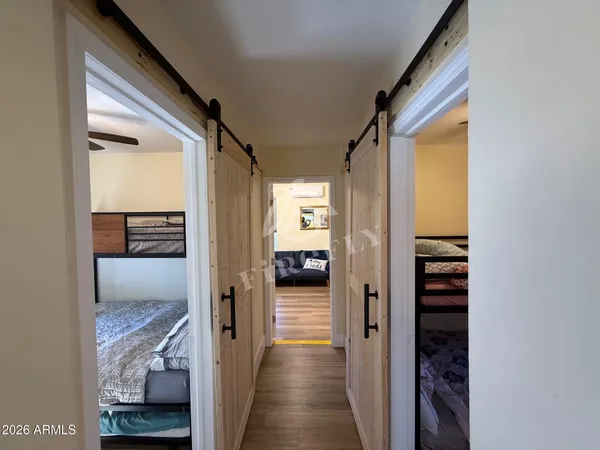 a view of a hallway with wooden floor and bedroom with wooden floor