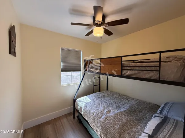 a bedroom with a bed and a chandelier fan