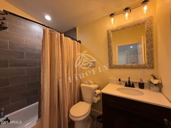 a bathroom with a sink a toilet a mirror and shower