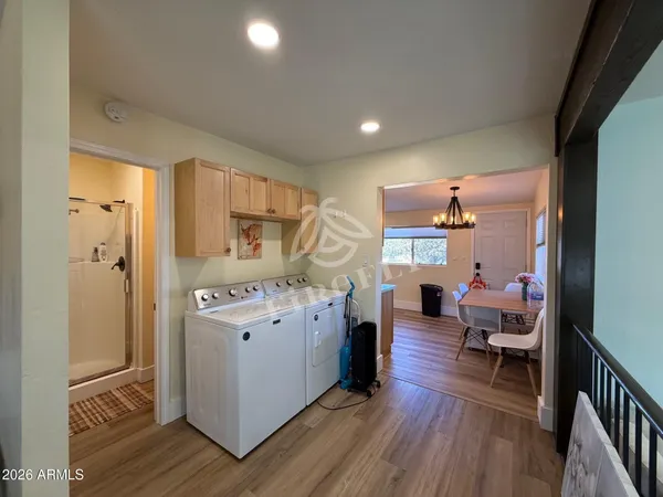 a kitchen view with furniture a refrigerator and wooden floor