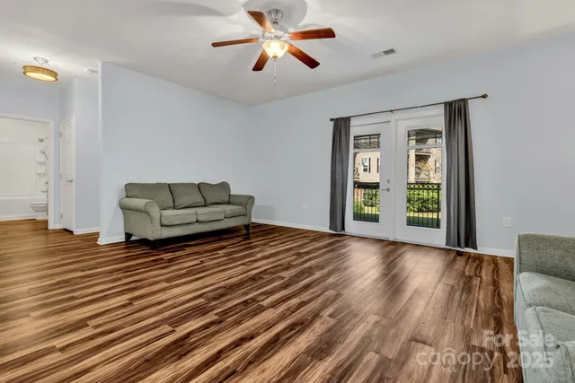 a living room with kitchen island furniture and a ceiling fan