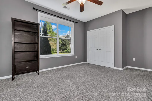 an empty room with chandelier fan