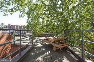 a view of a balcony with wooden floor and outdoor seating