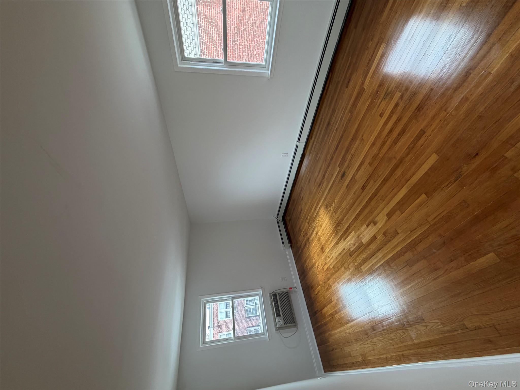 144-50 25th Road Queens, NY 11354 - Photo 17 of 20 a view of empty room with wooden floor and fan