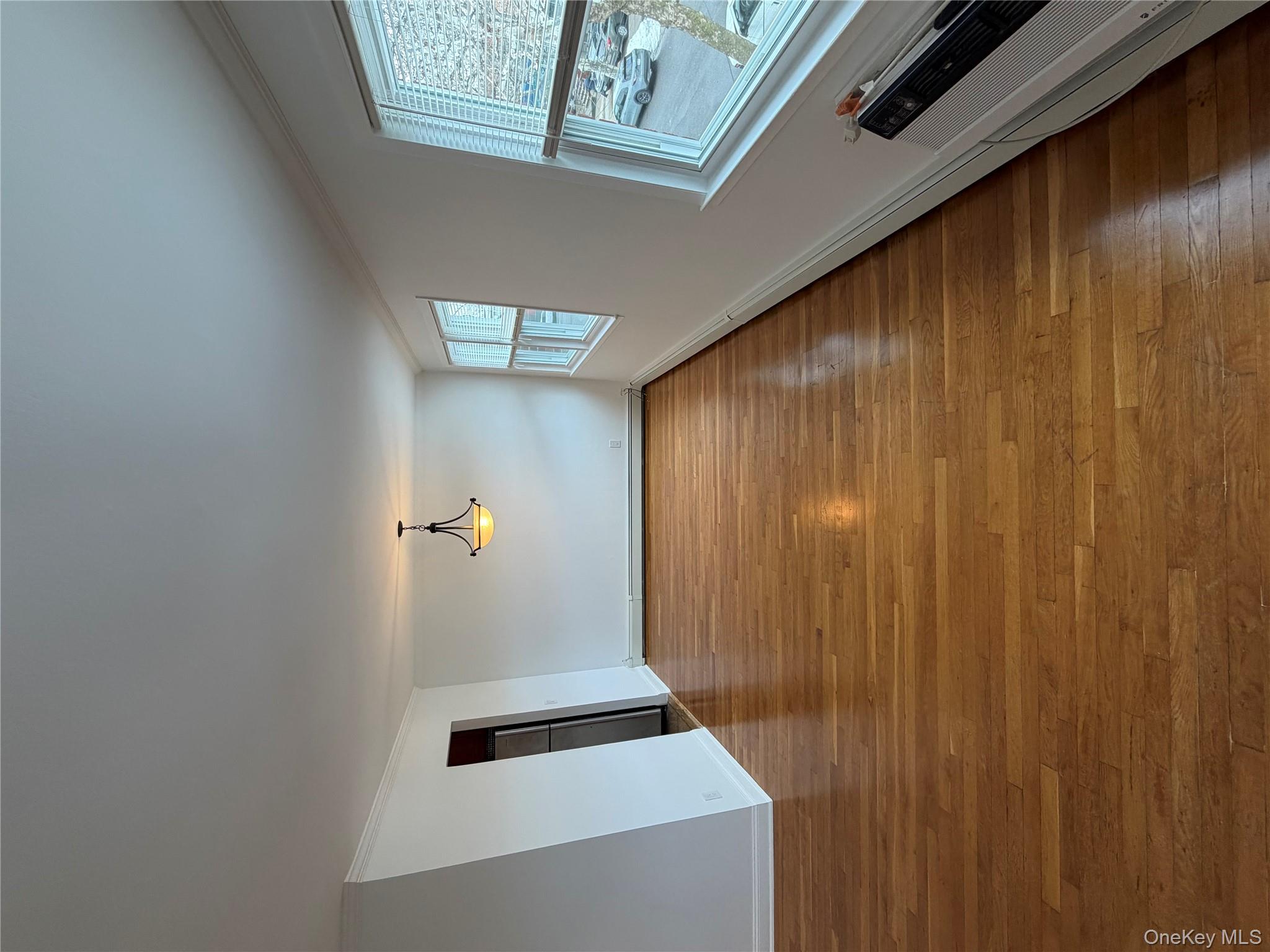 144-50 25th Road Queens, NY 11354 - Photo 3 of 20 a view of an empty room with window and wooden floor
