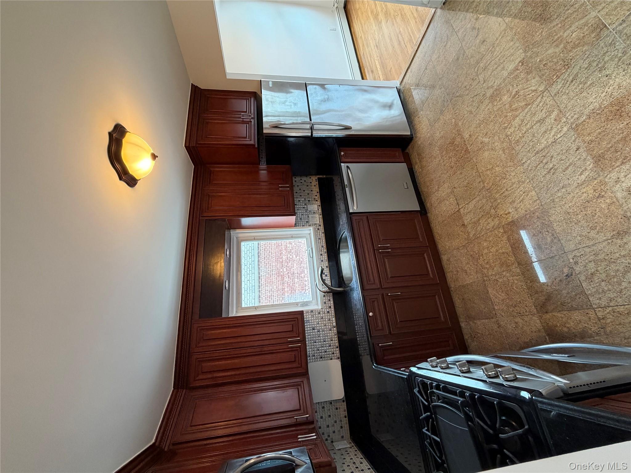 144-50 25th Road Queens, NY 11354 - Photo 5 of 20 a kitchen with granite countertop a stove cabinets and refrigerator