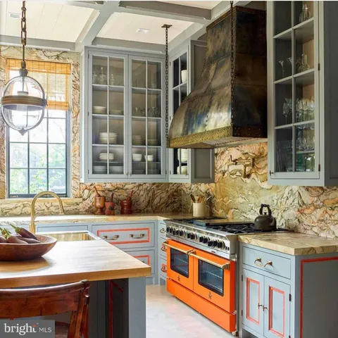 front view of a brick house with a large windows and large trees