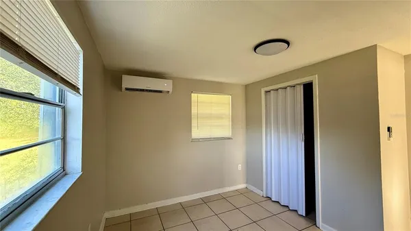 a view of an empty room with window and a livingroom
