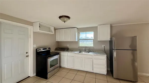 a kitchen with a white stove a sink and refrigerator