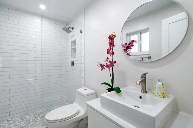 a bathroom with a sink a toilet and shower