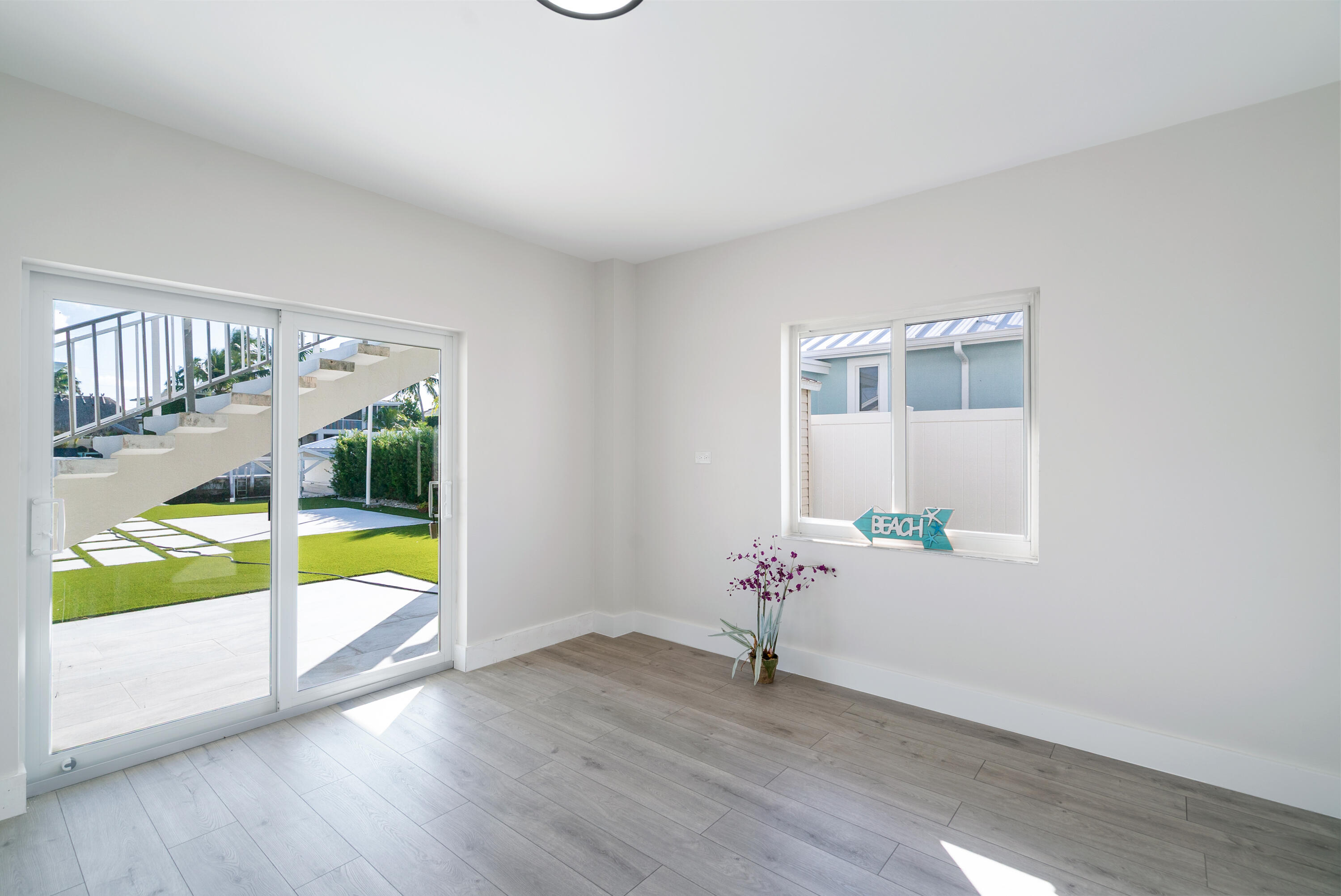 392 Laguna Avenue Key Largo, FL 33037 - Photo 10 of 42 a view of an empty room with wooden floor and a window