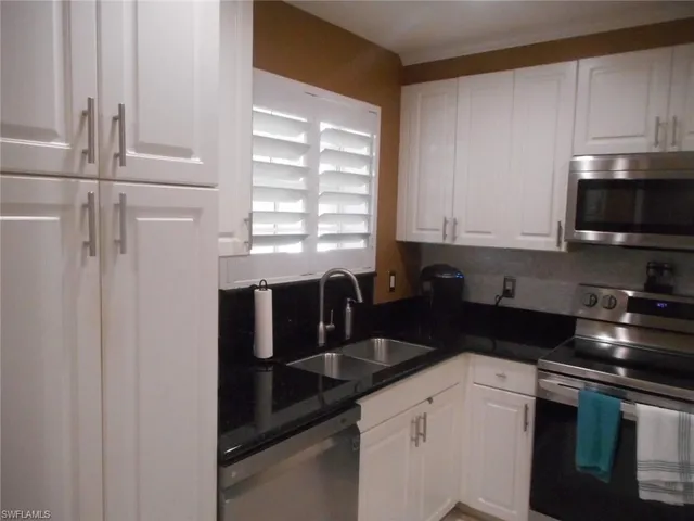 a kitchen with stainless steel appliances a refrigerator a sink a stove and cabinets