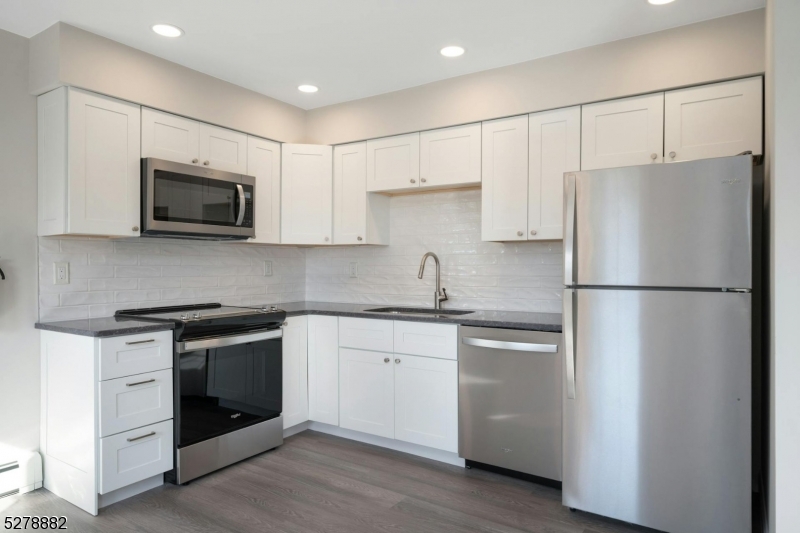 80 East Main Street, Unit 5 Mendham, NJ 07945 - Photo 1 of 28 a kitchen with stainless steel appliances granite countertop white cabinets a microwave a sink and a refrigerator
