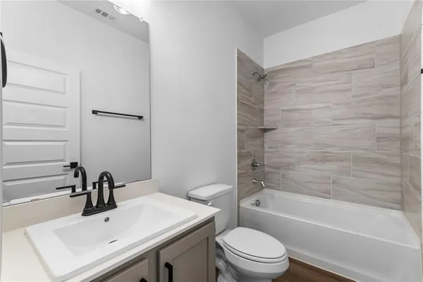 a bathroom with a sink toilet vanity and bathtub