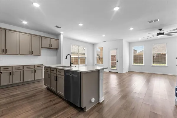 a large kitchen with stainless steel appliances granite countertop a large counter top and wooden floors