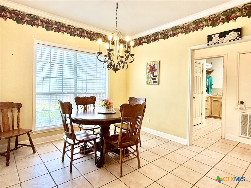 415 South Trinity Street Edna, TX 77957 - Photo 19 of 46 a view of a dining room with furniture and chandelier