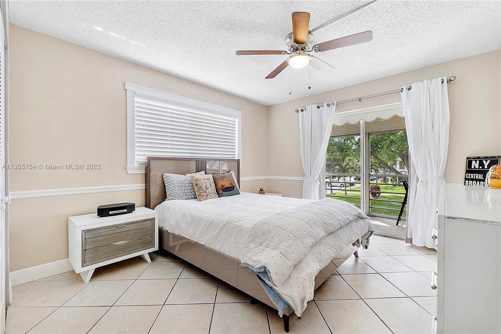 357 Durham, Unit 357 Deerfield Beach, FL 33442 - Photo 16 of 41 a bedroom with a bed a chandelier and a window