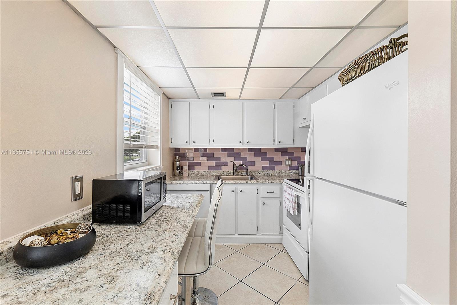 357 Durham, Unit 357 Deerfield Beach, FL 33442 - Photo 22 of 41 a kitchen with a refrigerator and a stove top oven