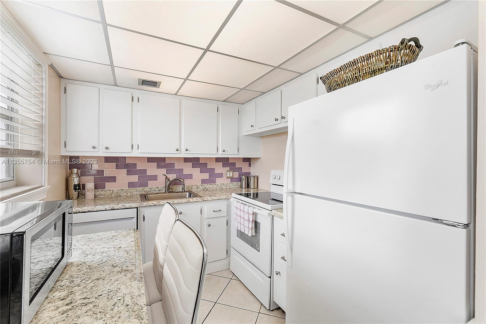 357 Durham, Unit 357 Deerfield Beach, FL 33442 - Photo 23 of 41 a kitchen with a refrigerator and a stove top oven
