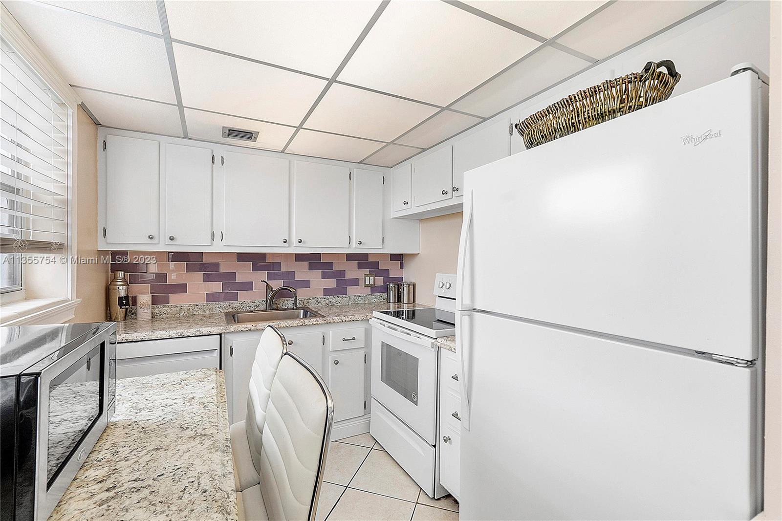 357 Durham, Unit 357 Deerfield Beach, FL 33442 - Photo 24 of 41 a kitchen with a refrigerator and a stove top oven