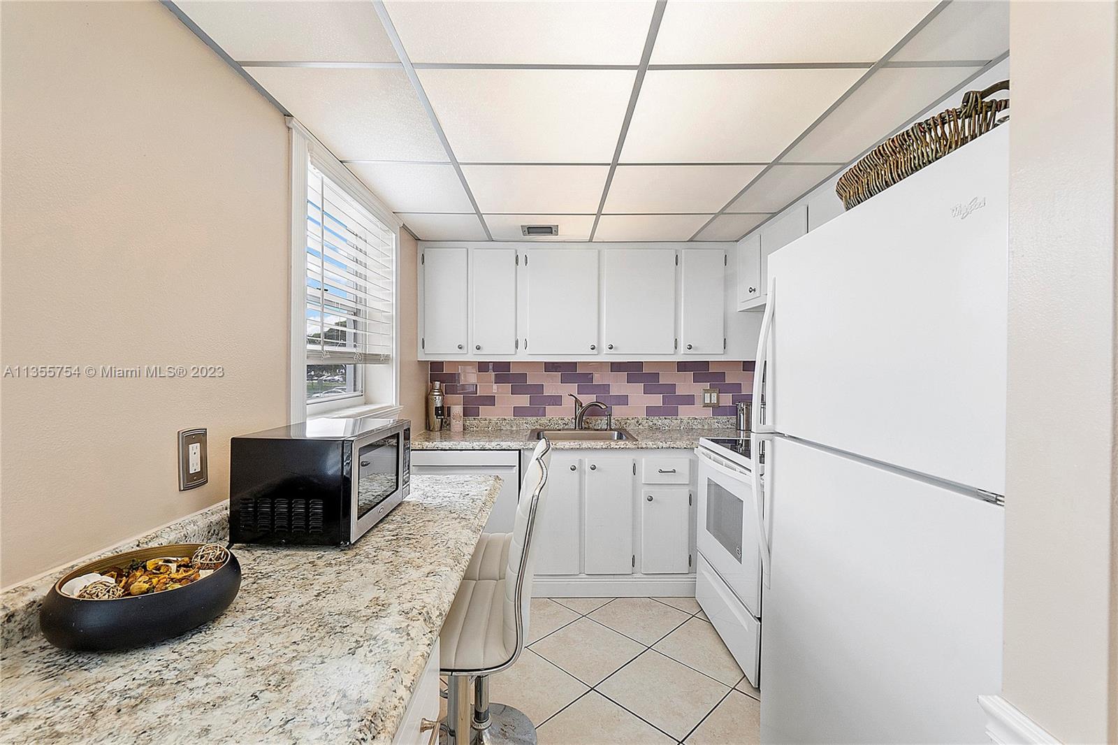 357 Durham, Unit 357 Deerfield Beach, FL 33442 - Photo 25 of 41 a kitchen with a refrigerator and a stove top oven