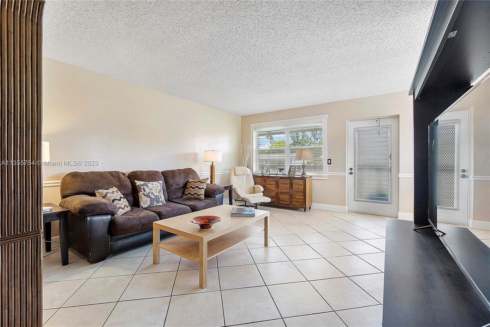 357 Durham, Unit 357 Deerfield Beach, FL 33442 - Photo 5 of 41 a living room with furniture and a floor to ceiling window