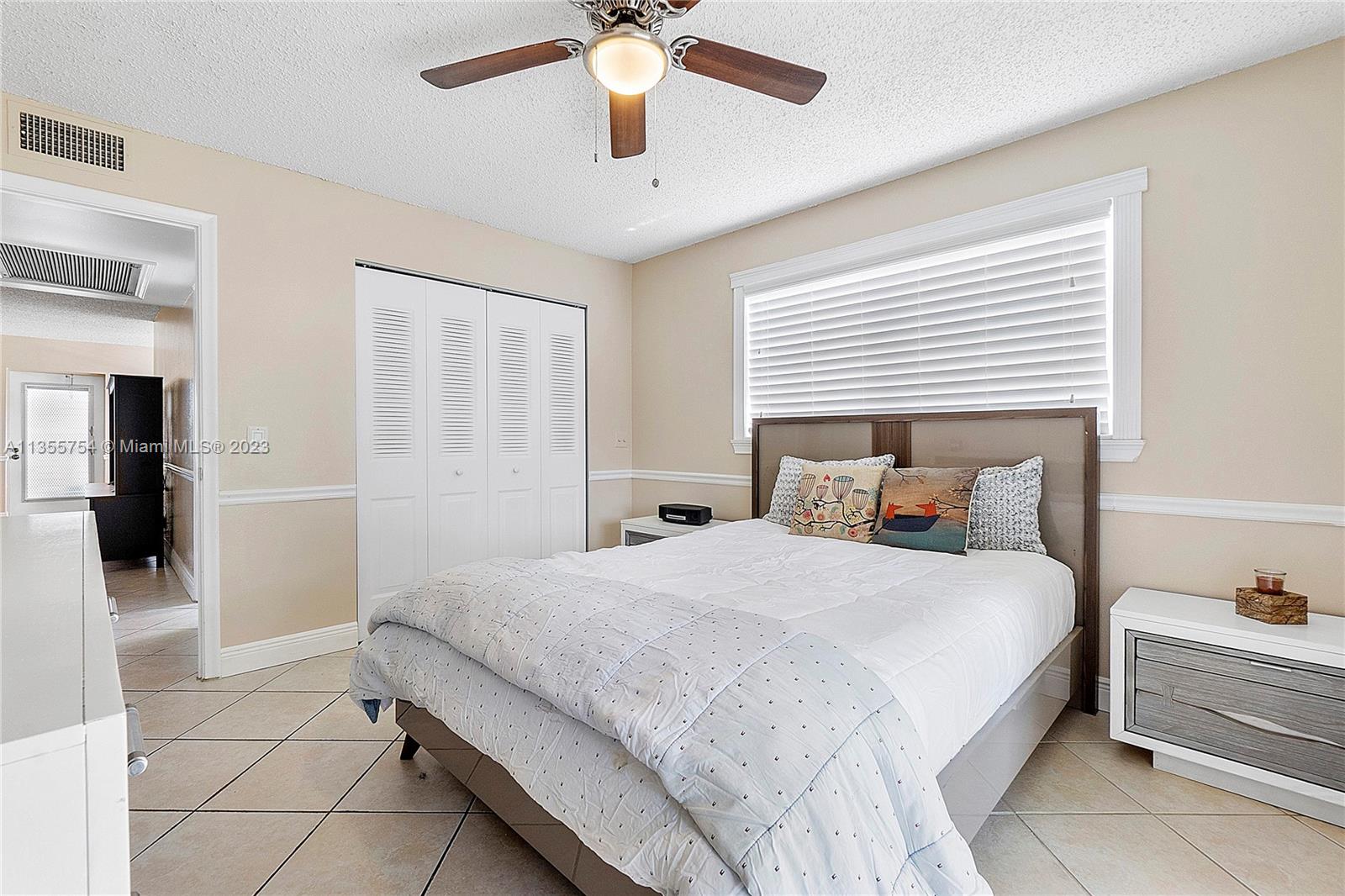 357 Durham, Unit 357 Deerfield Beach, FL 33442 - Photo 8 of 41 a bedroom with a bed and a chandelier
