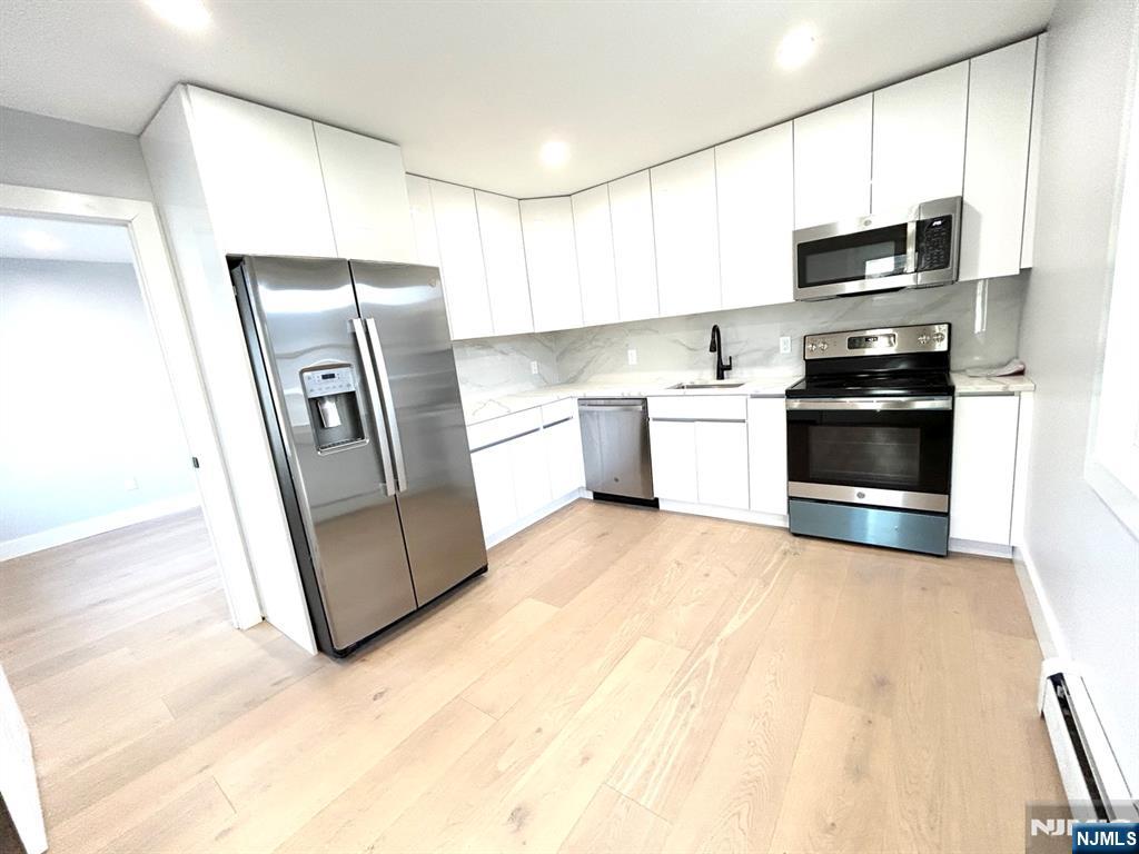 a kitchen with stainless steel appliances granite countertop a refrigerator stove and sink