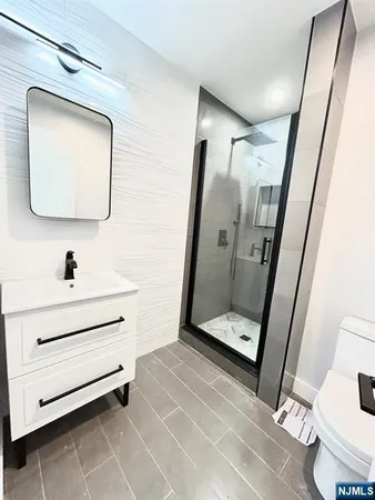 a bathroom with a sink mirror vanity and toilet