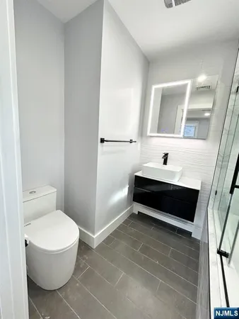a bathroom with a toilet a sink and a mirror