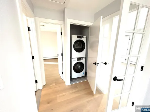 a view of walk in closet with clothes and washer